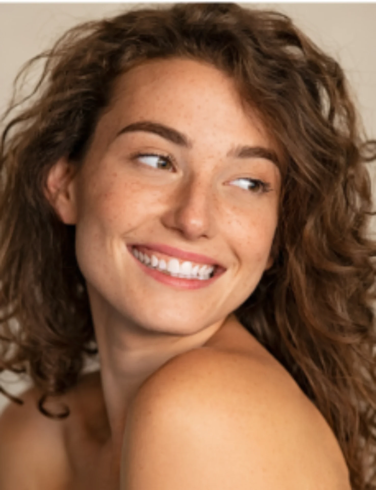 Smiling woman with naturally rejuvenated, freckled skin after evidence-based skin rejuvenation